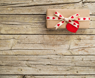 情人节礼品盒和红色的心形标记在木板上
