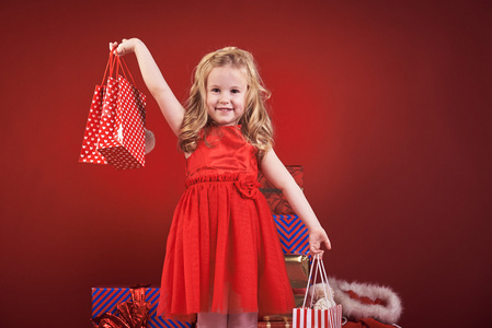 可爱的小女孩，与圣诞礼物红色背景上