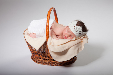 刚出生的婴儿睡在他的胃在篮子里