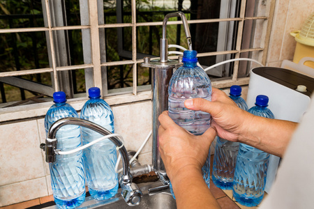 人回收空塑料瓶从过滤自来水