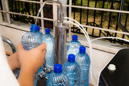 人回收空塑料瓶从过滤自来水