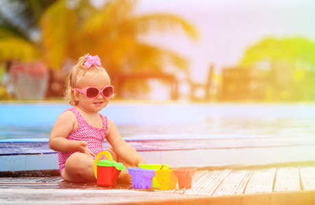 可爱的小女孩在游泳池在海滩玩