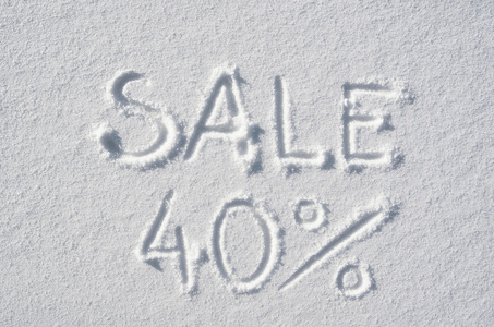 文字销售40手工写在雪背景上。 水平后哨