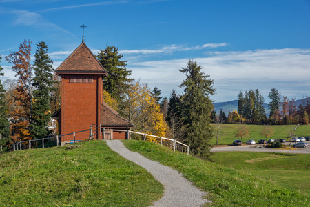 古老的教堂和秋天的树木附近的阿尔卑斯山 Rigi
