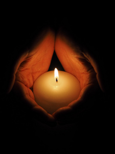 蜡烛和黑色背景上的手图片