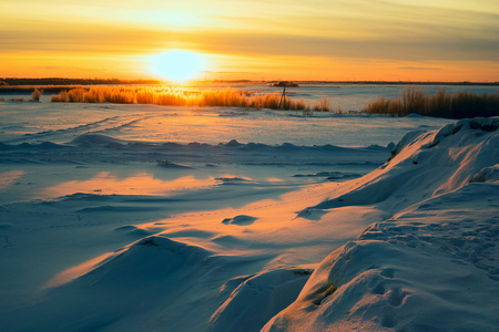 明亮的太阳日落在冬天与大雪漂泊
