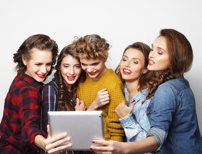 考虑自拍照与数字平板电脑的五个时髦女孩朋友
