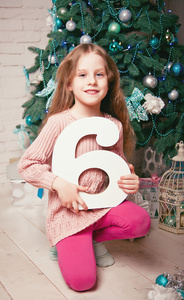 漂亮的小女孩在圣诞树下