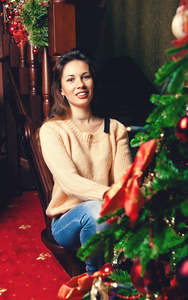 在圣诞节树附近一名年轻女子的画像