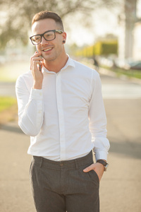 戴眼镜的男人谈一谈在手中的移动电话