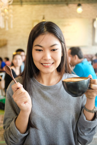 美丽可爱的亚洲女孩在艺术咖啡馆与咖啡微笑的女人咖啡店