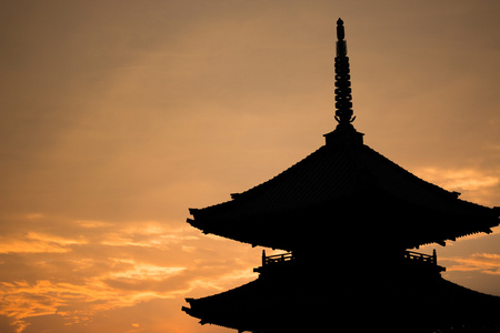 在日落期间在日本的日本寺庙剪影