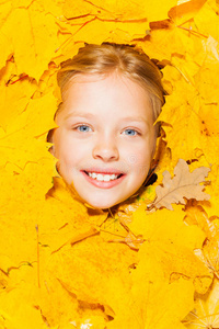 秋天树叶里一个金发小女孩的脸