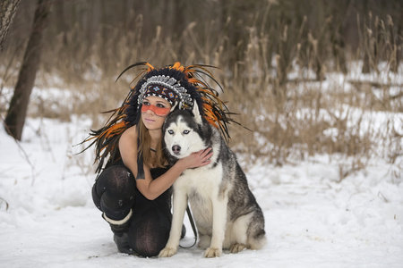 一只狗在冬天森林里的女孩