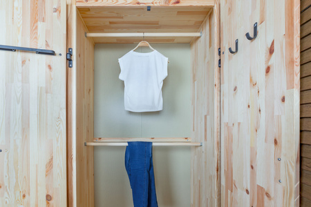 衬衫和裤子在木制衣柜图片