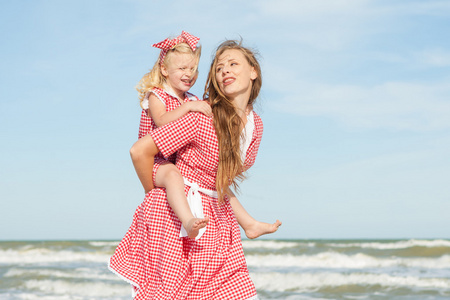 母亲和她的女儿在海滩上玩
