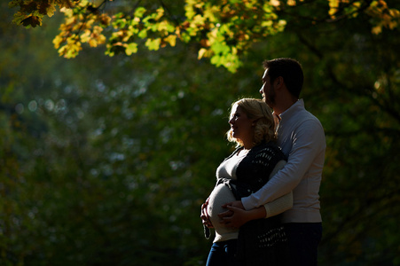 丈夫和怀孕的妻子，走在公园里