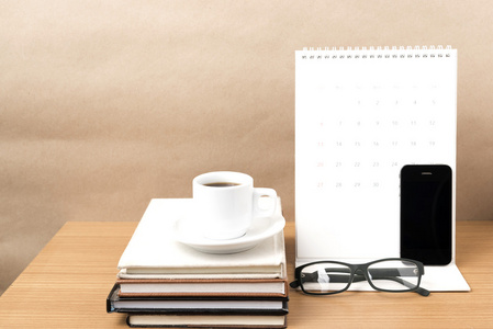 咖啡，电话，眼镜，堆栈的书和日历