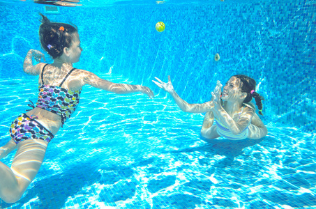 孩子们在水下，快乐积极的女孩有下水，孩子们运动家庭度假的乐趣的游泳池里游泳