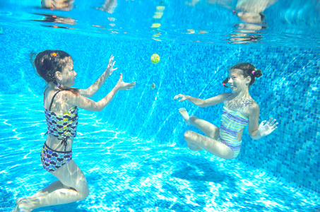 孩子们在水下，快乐积极的女孩有下水，孩子们运动家庭度假的乐趣的游泳池里游泳