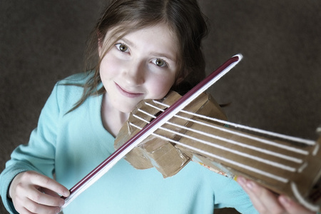 年轻的女孩玩玩具小提琴