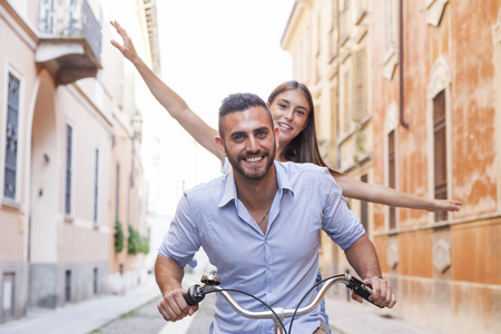 年轻恩爱的夫妻，骑自行车穿过城市