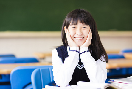 教室里书的快乐漂亮的学生女孩