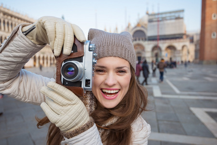 在圣马可广场用复古相机拍照的女人