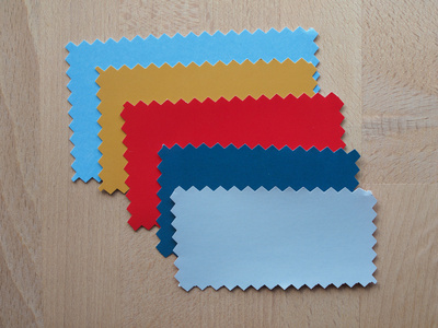 蓝色，红色，黄色的纸样，锯齿状边框，用粉红色剪刀切割