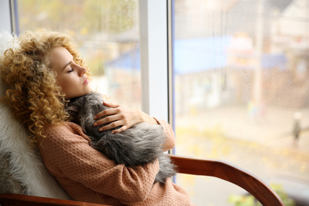 女人和猫在窗口旁边