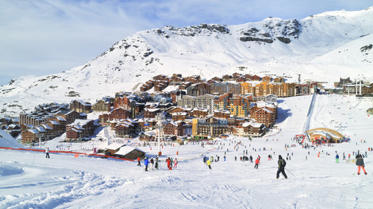 滑雪和滑雪板爱好者去疯狂到法国村，欧洲最高的滑雪度假胜地宽边坡。下坡滑雪与阿尔卑斯山雪峰周围高山村庄