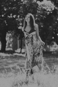 照片在公园里的漂亮女孩。一个年轻的黑发穿在微妙的野花。黑色和白色的专业化妆的女孩照片