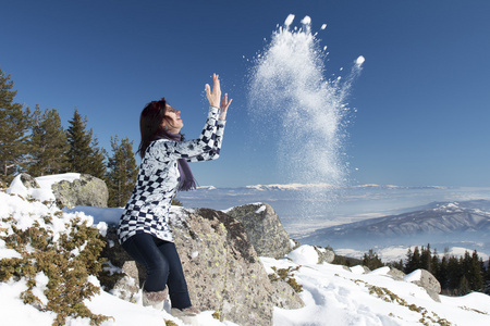 女人扔在冬天的雪在空中