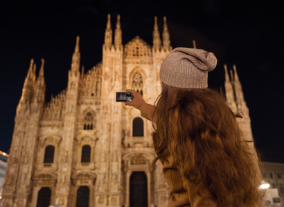 在米兰晚上给杜莫拍照的年轻女子