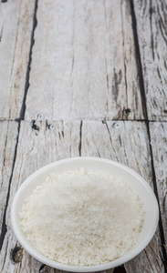 干椰子粉，白色碗在木制背景上