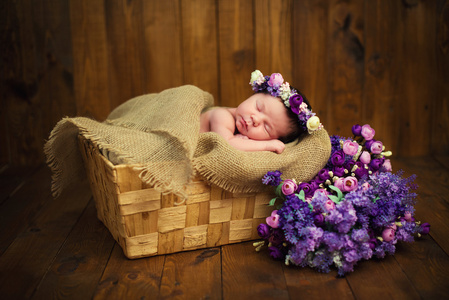 新生女婴用柳条篮子紫色野花一束花环