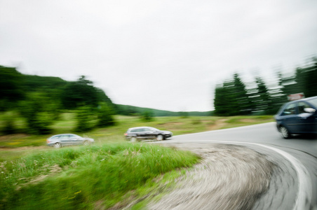 三辆车在一个弯道的乡村公路道路上驾驶