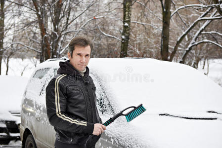 冬天开车的司机在雪地里到处刷洗