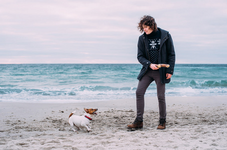 男人在海滩上玩狗