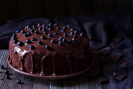 巧克力蛋糕装饰着黑莓上老式木制桌子背景