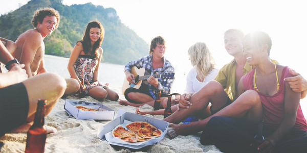 朋友在沙滩上吃披萨