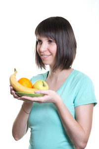 健康的饮食。女孩拿着水果，孤立在白色背景上的一道菜