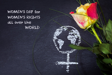 玫瑰和一支粉笔在黑板 概念女性权利 示例文本上绘制地球全球女性签订