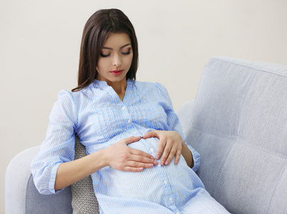 怀孕的女人在房间里的沙发上休息