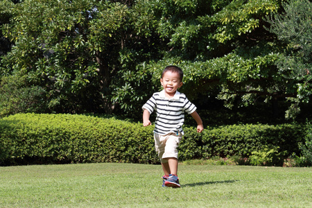 在草地上奔跑的日本男孩3岁