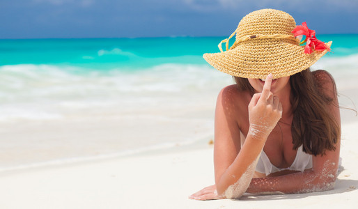 快乐的年轻女人，戴着草帽在海滩上。没有脸