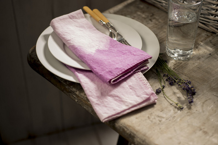 堆白色餐盘和紫色布餐巾