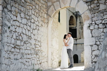 对幸福的夫妇新娘和新郎在婚礼当天酒店，意大利温柔地拥抱