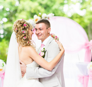 祝新婚快乐浪漫的情侣在粉红色装饰着鲜花的婚礼过道上跳舞
