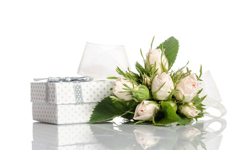 束白玫瑰和白色背景上的礼品盒